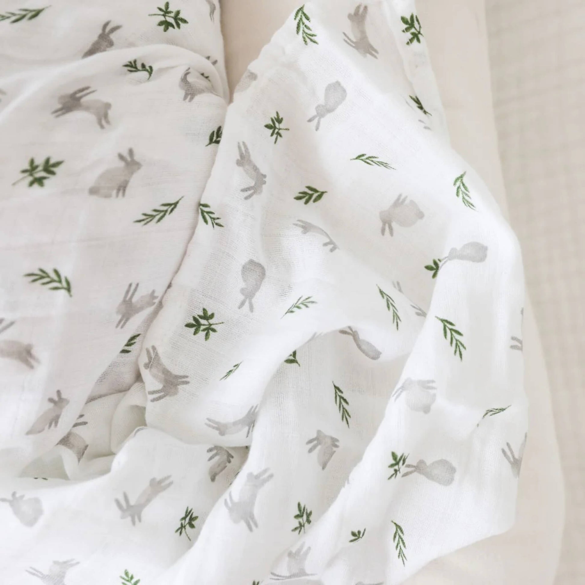 Close-up of the muslin fabric showing the delicate weave and detailed bunny and leaf design.