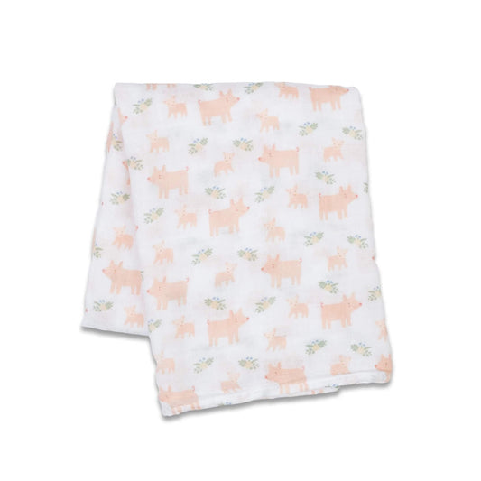 Lightweight muslin swaddle folded flat, showing a repeating pattern of pink pigs and tiny green sprigs across the white cotton fabric.
