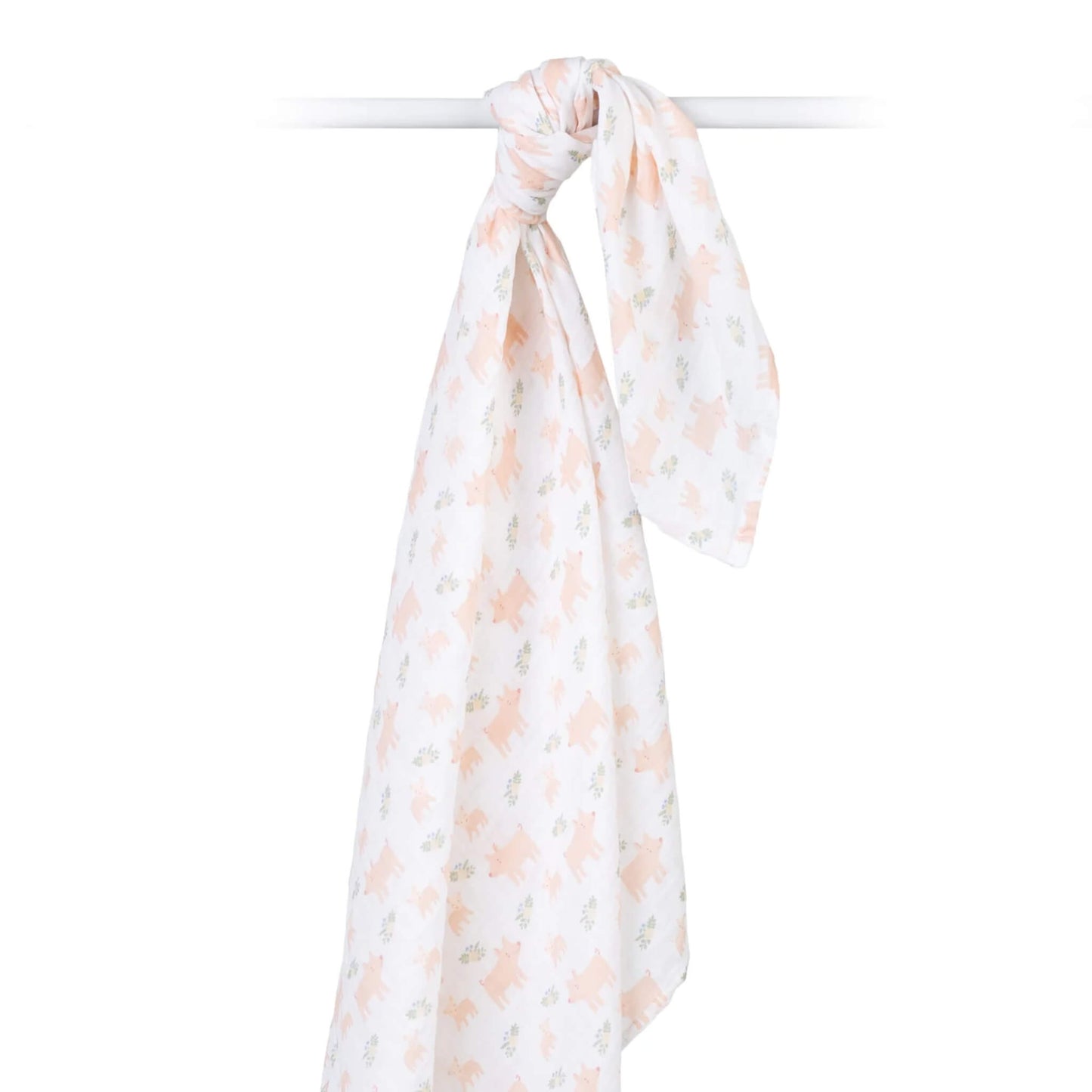 Cotton muslin swaddle draped over a rod, highlighting its airy weave and delicate pig and floral print.