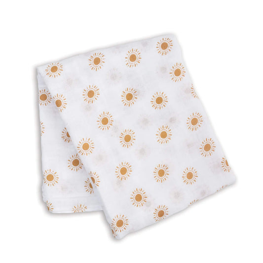 Folded muslin swaddle featuring a repeating print of mustard-yellow suns on lightweight white cotton fabric.