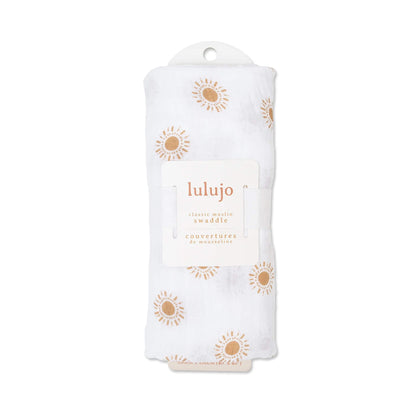 Swaddle rolled in Lulujo packaging with label visible, highlighting the golden sun print through the fabric.
