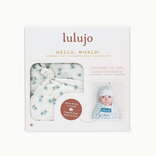Lulujo Blueberries Hello World gift box displaying muslin swaddle, knotted hat and name tag sticker - perfect baby shower gift for expecting parents.