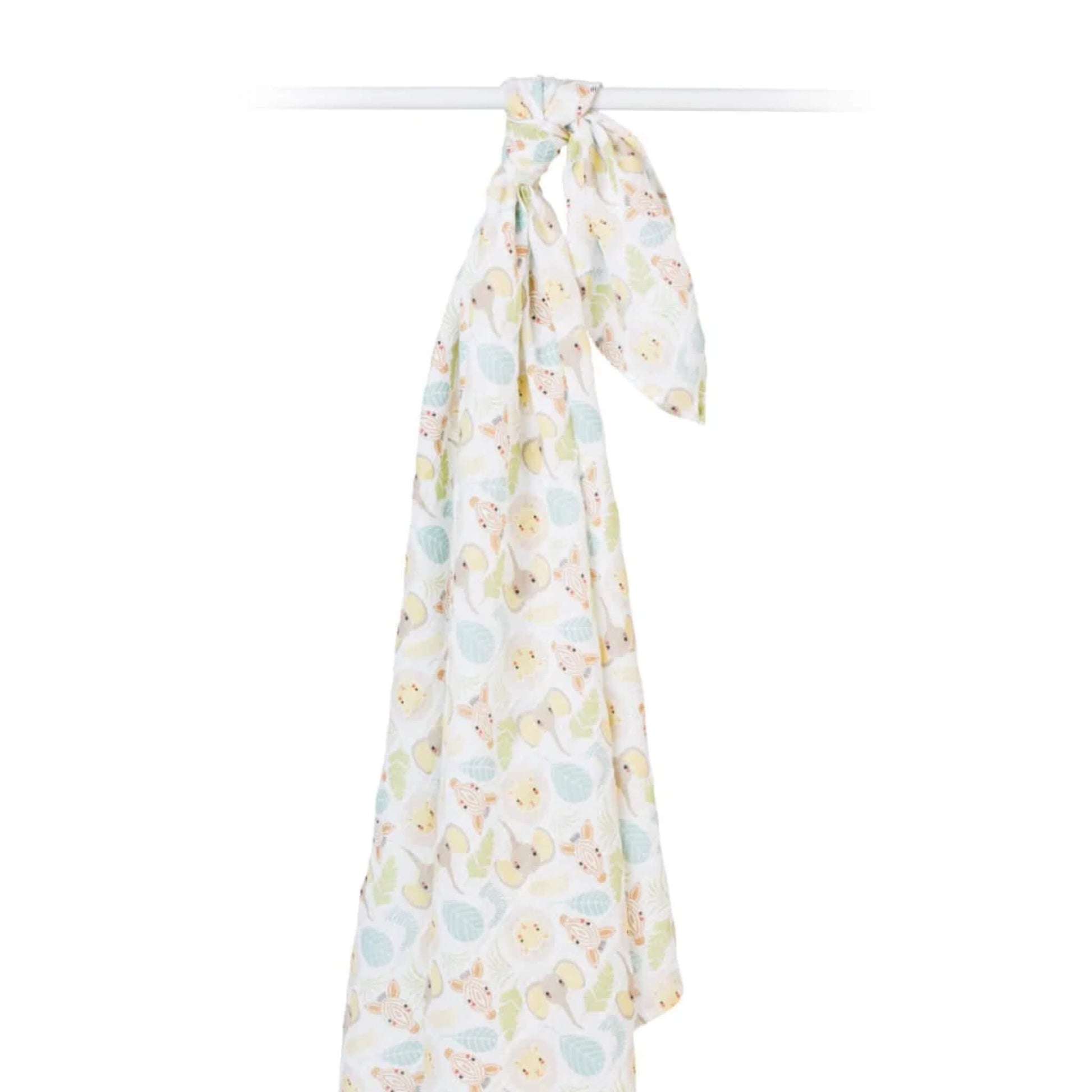 Lightweight muslin swaddle draped from a rail to display its airy texture and playful safari pattern of animals and leaves.