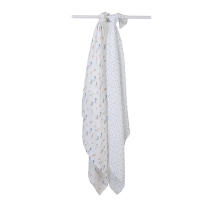 Two muslin swaddles knotted over a white rod, one with a dog print and one with a scattered star pattern.