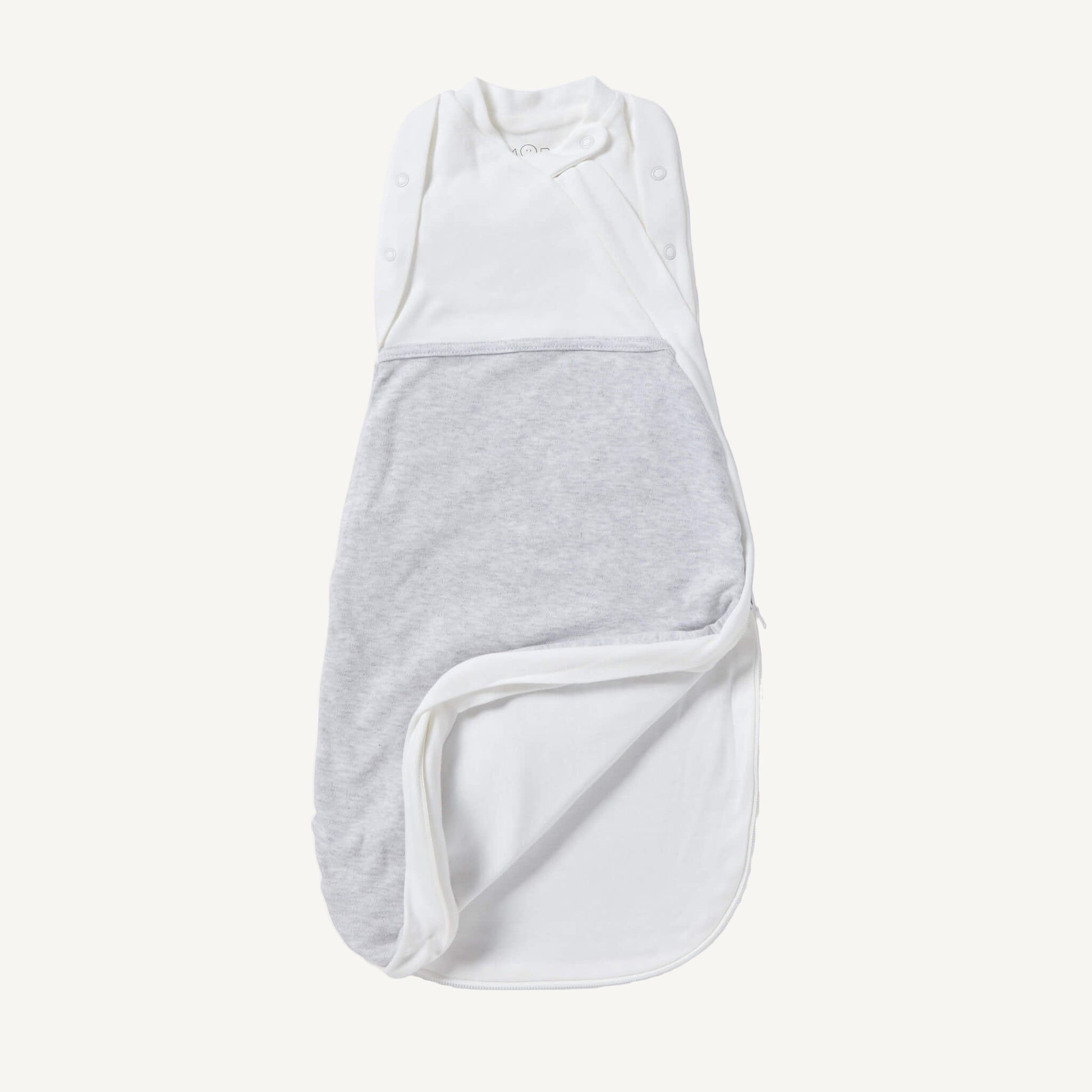 A newborn swaddle bag in grey shown partially unzipped at the bottom, revealing the soft inner lining and wrap-style chest panel with poppers.
