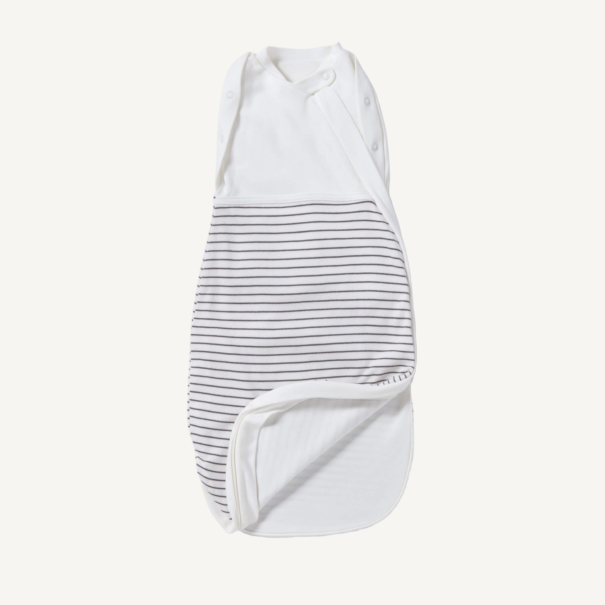 A newborn swaddle bag in grey stripe shown partially unzipped at the bottom, revealing the soft inner lining and wrap-style chest panel with poppers.