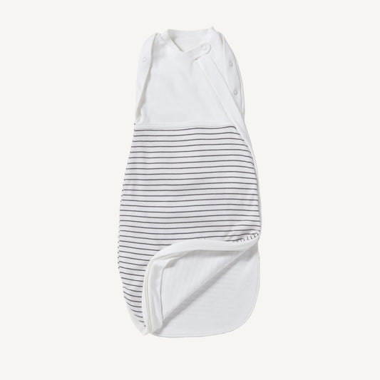 A newborn swaddle bag in grey stripe shown partially unzipped at the bottom, revealing the soft inner lining and wrap-style chest panel with poppers.