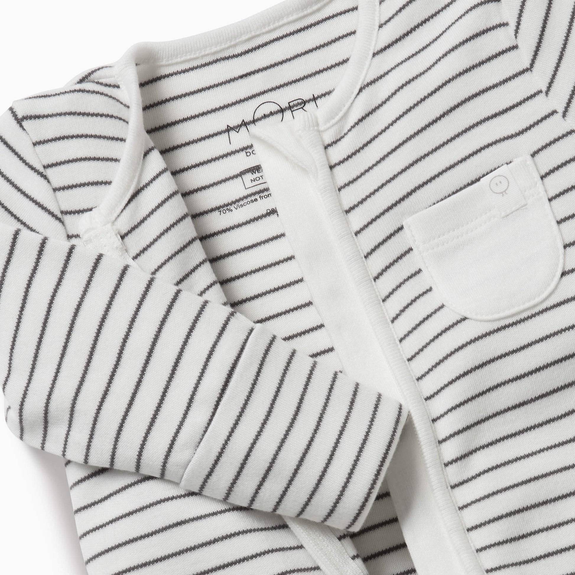 A close-up of a grey striped baby sleepsuit showing the soft neckline, concealed zip and small white chest pocket.