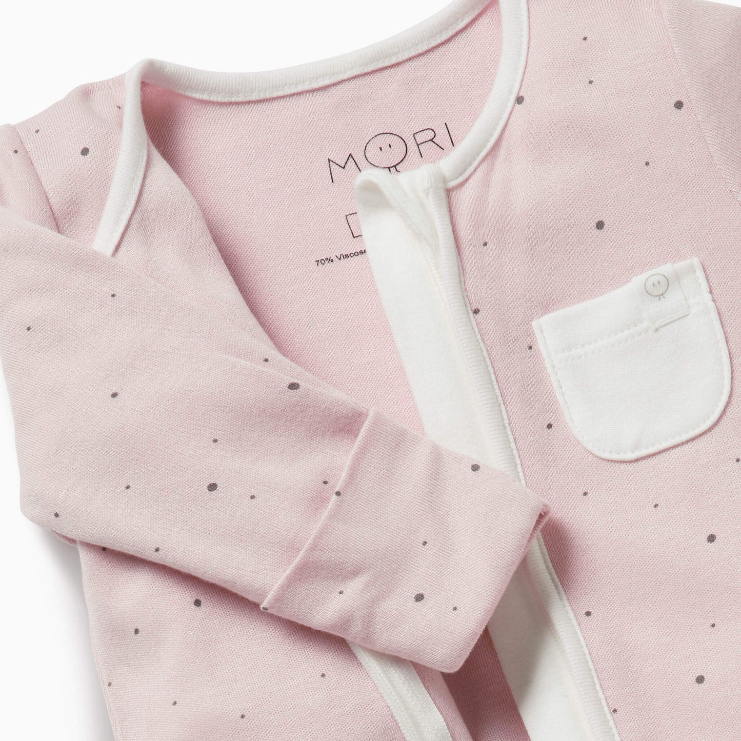 Close-up of a pink baby sleepsuit with a white pocket for added detail.