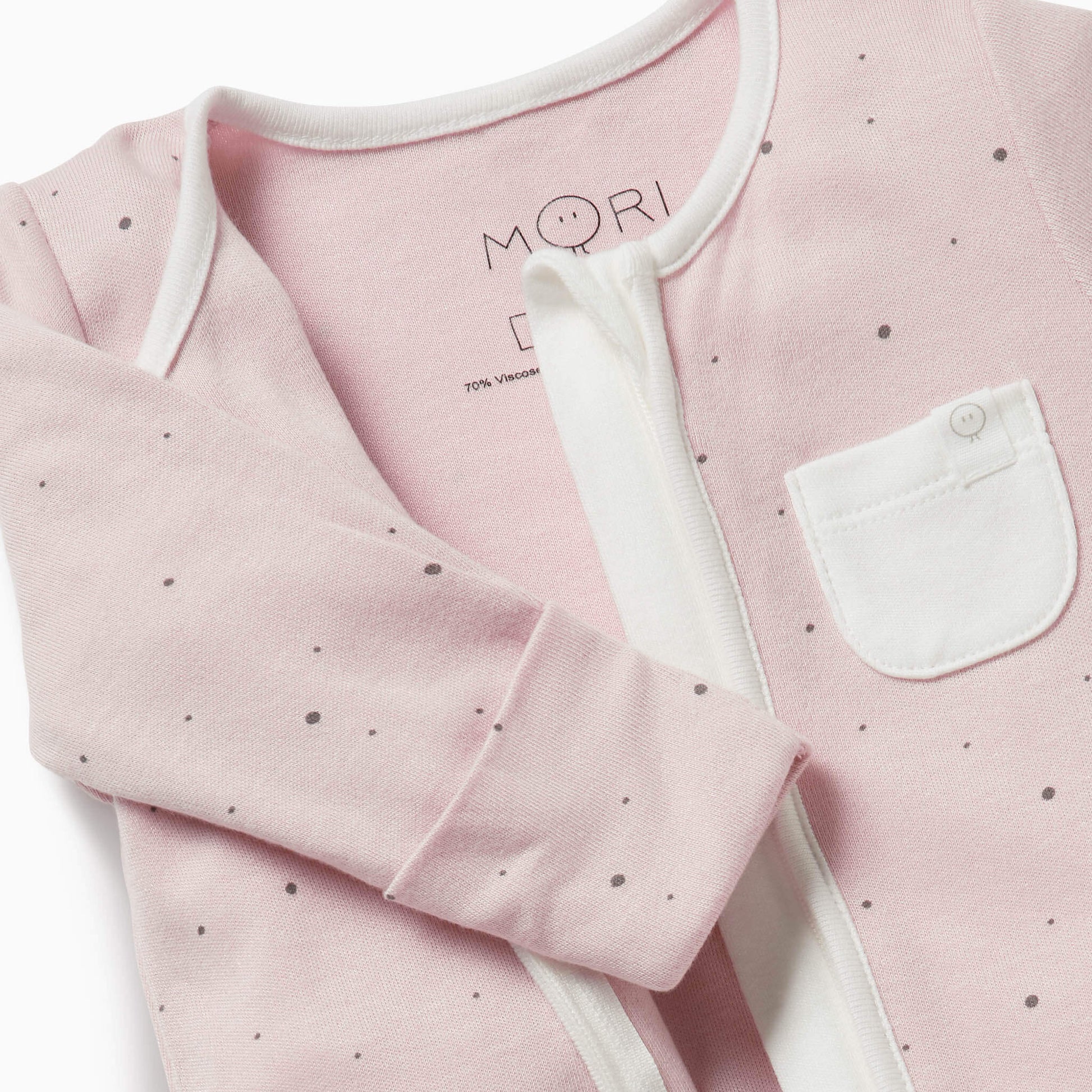 Close-up of a pink baby sleepsuit with a white pocket for added detail.