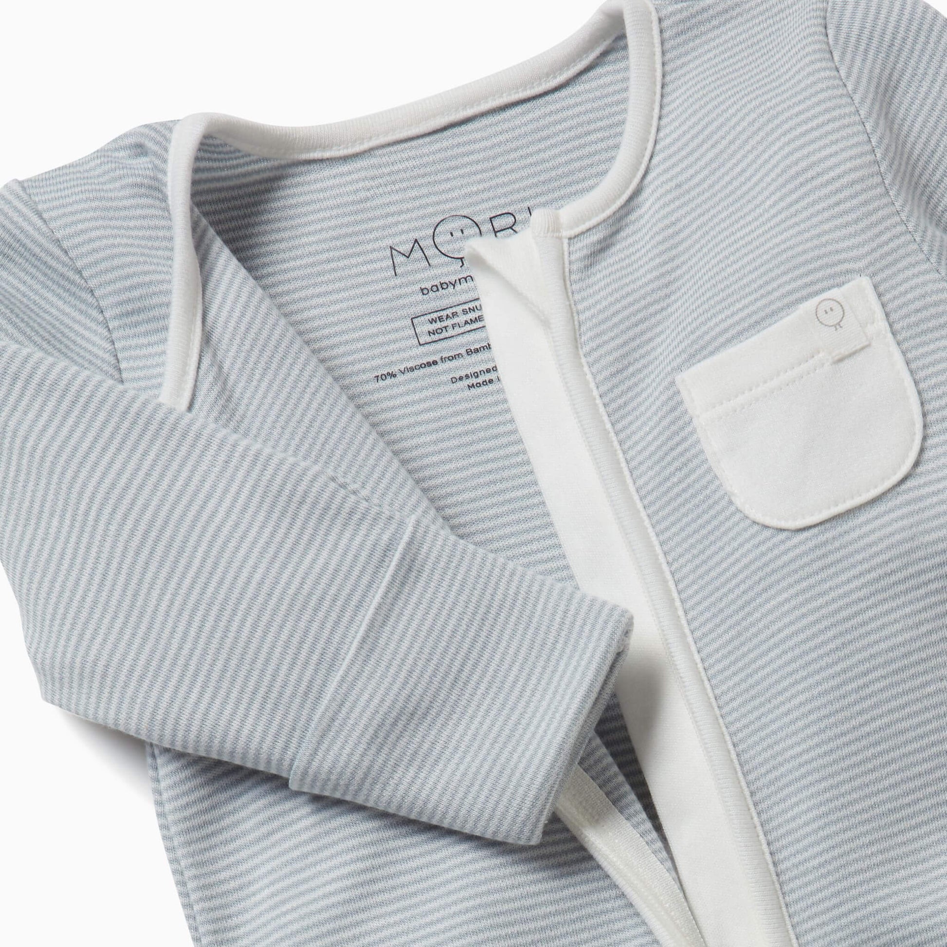 Close-up of a blue striped sleepsuit shown partly unzipped to reveal the inner seams and the soft fabric texture.