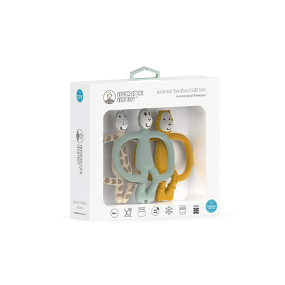 A close-up angled view of the boxed set containing three silicone animal-shaped teethers in beige, sage green and mustard inside white retail packaging.