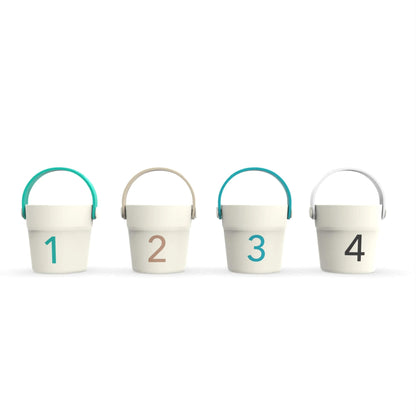 A set of four cream toy buckets shown from the back, each with a bold number from one to four printed on the surface.