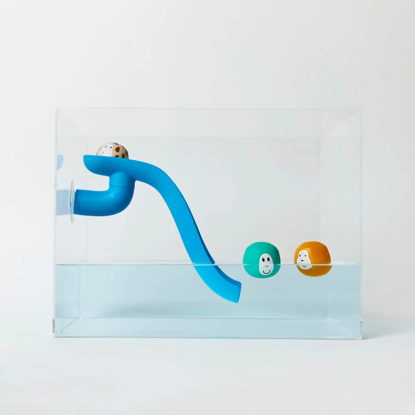 Blue curved bath toy slide attached inside a clear water tank with three floating animal character balls resting at different points along the slide and water surface.