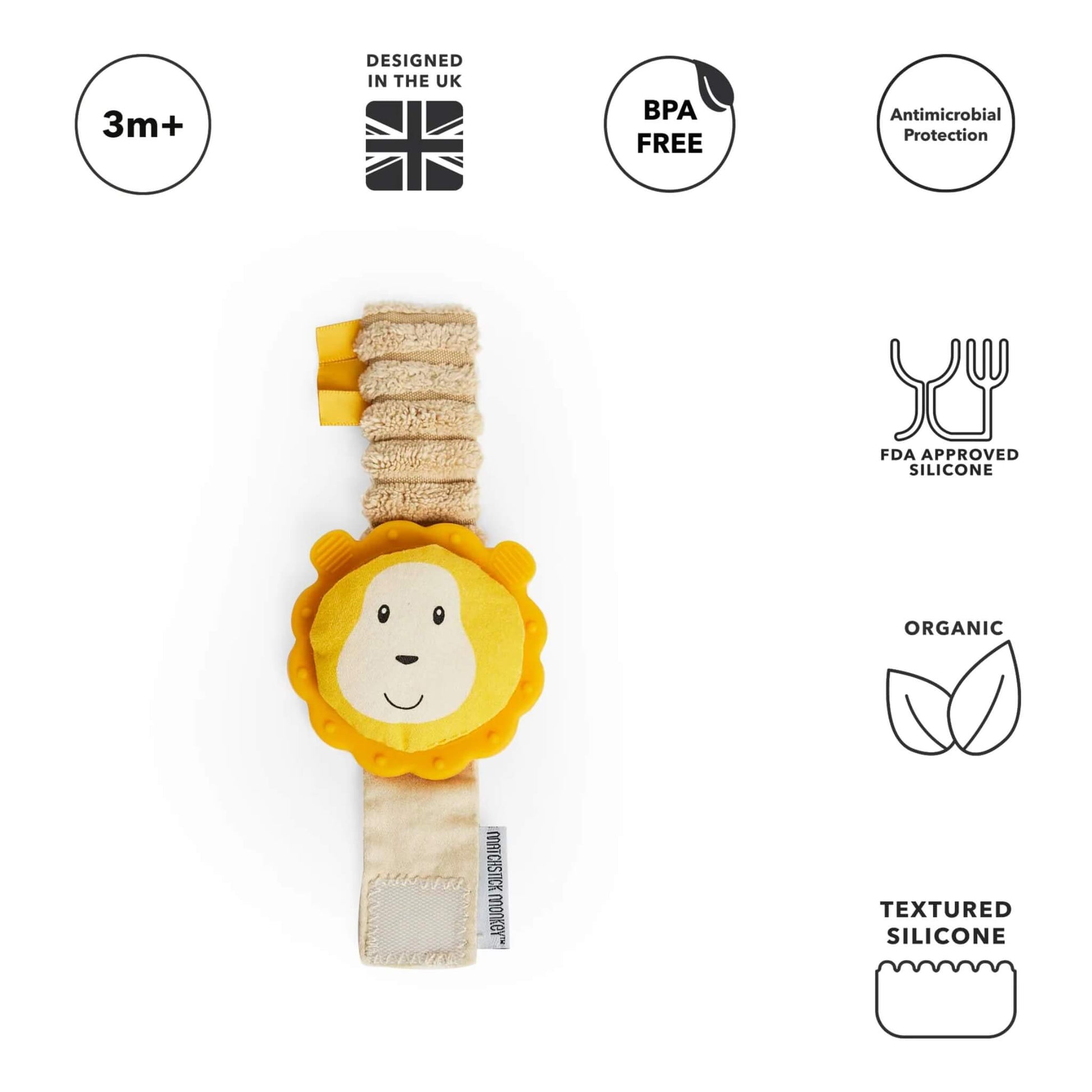 A wrist teether lies flat with a bright yellow lion-shaped silicone topper attached to a soft, stretchy fabric strap with ribbon tags.