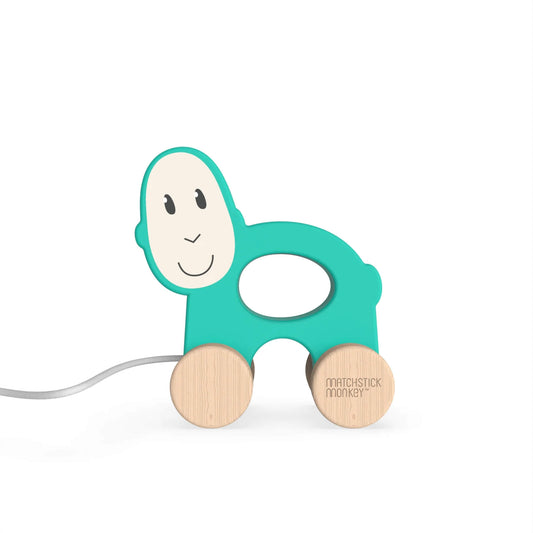 Matchstick Monkey Pull Along Toy shown as a turquoise wooden pull-along animal with a cut-out centre and natural wood wheels.