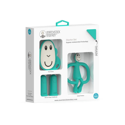 Retail packaging with a clear window showing a green flat teether, two silicone finger toothbrushes, and a monkey-shaped teether inside the box.