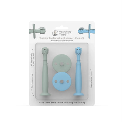 Pack of two silicone baby training toothbrushes with removable safety stoppers displayed inside retail packaging.