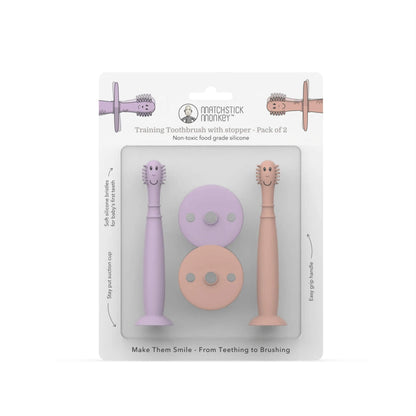 Pack of two silicone baby training toothbrushes with removable safety stoppers displayed inside retail packaging.