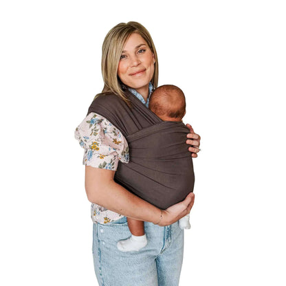 A mother wearing the Moby Classic Baby Wrap in Hickory brown, holding her baby securely against her chest.