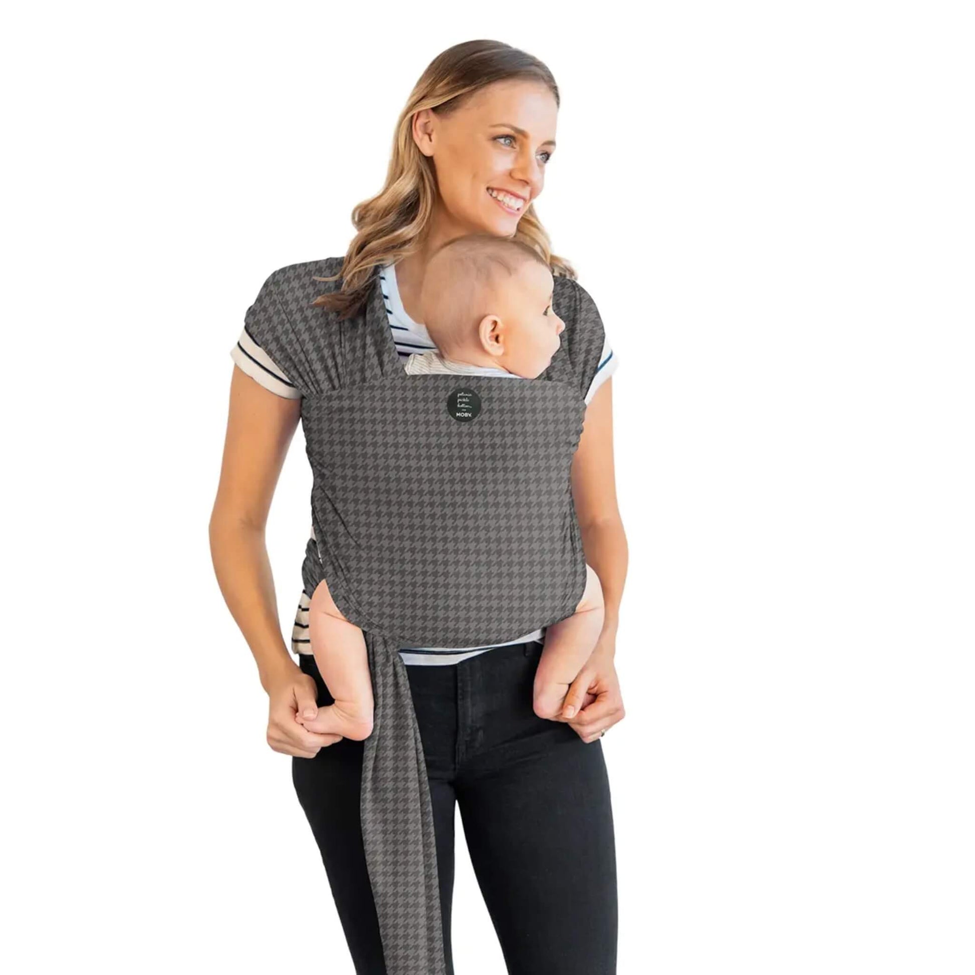 Moby Classic Baby Wrap in a grey houndstooth pattern holding a baby against an adult’s chest, with the wrap tied securely around the torso.