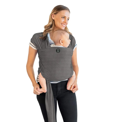 Moby Classic Baby Wrap in a grey houndstooth pattern holding a baby against an adult’s chest, with the wrap tied securely around the torso.
