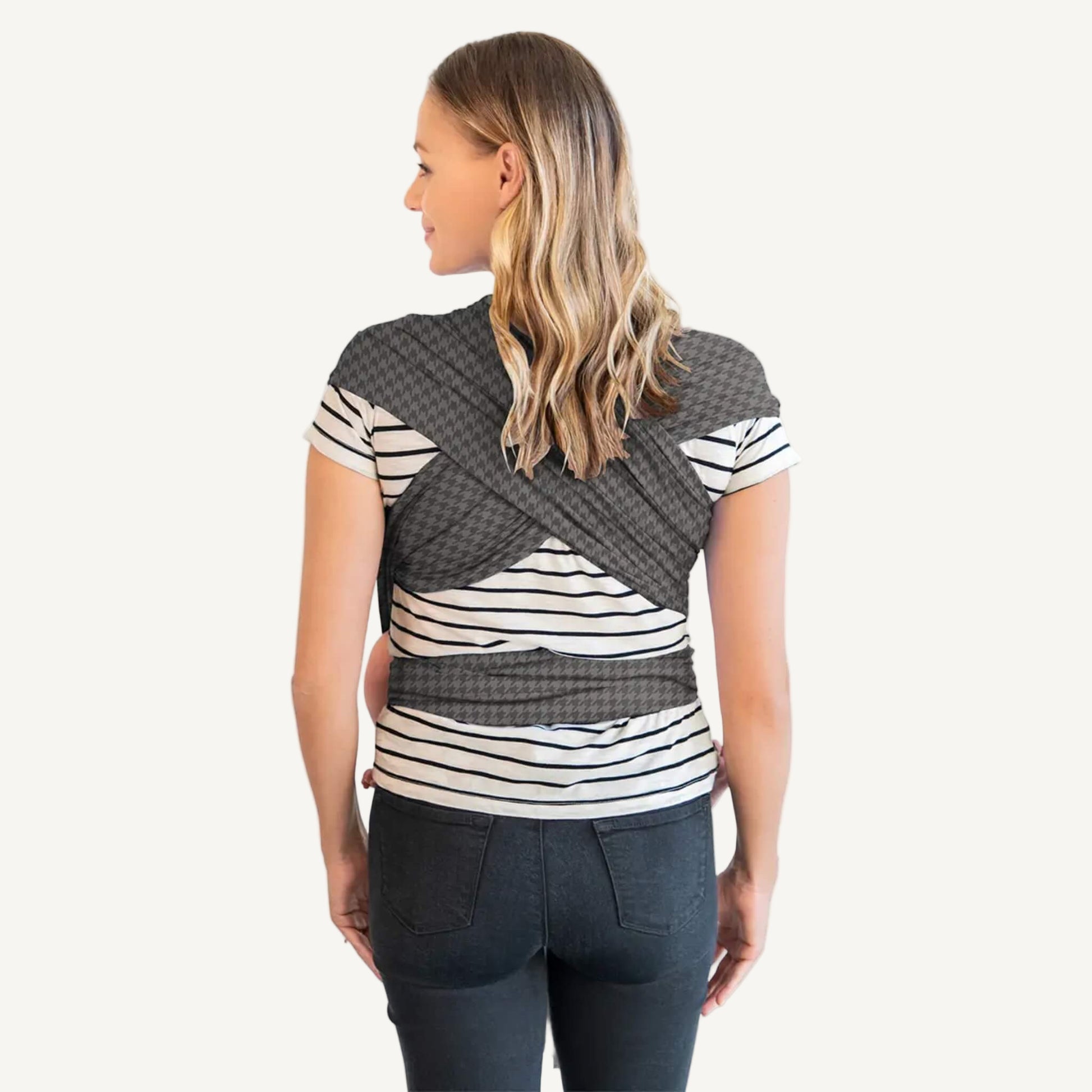 Back view of an adult wearing a grey houndstooth-patterned wrap with the fabric crossed over the shoulders and tied around the waist.