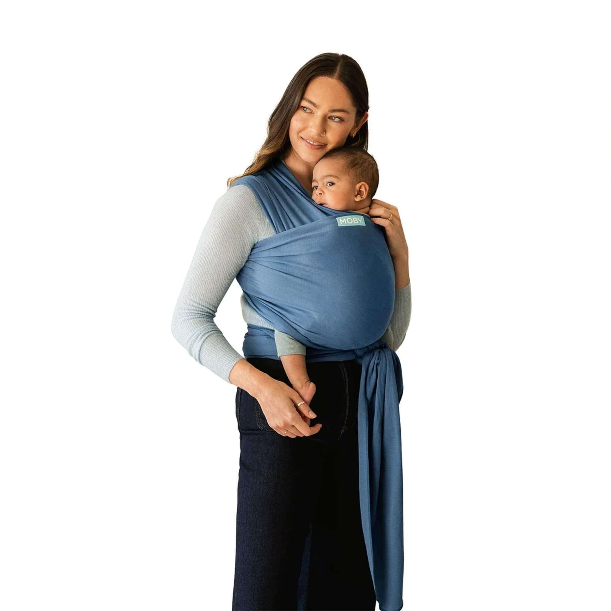 A mother wearing the Moby Classic Baby Wrap in Ocean blue, holding her baby securely against her chest.
