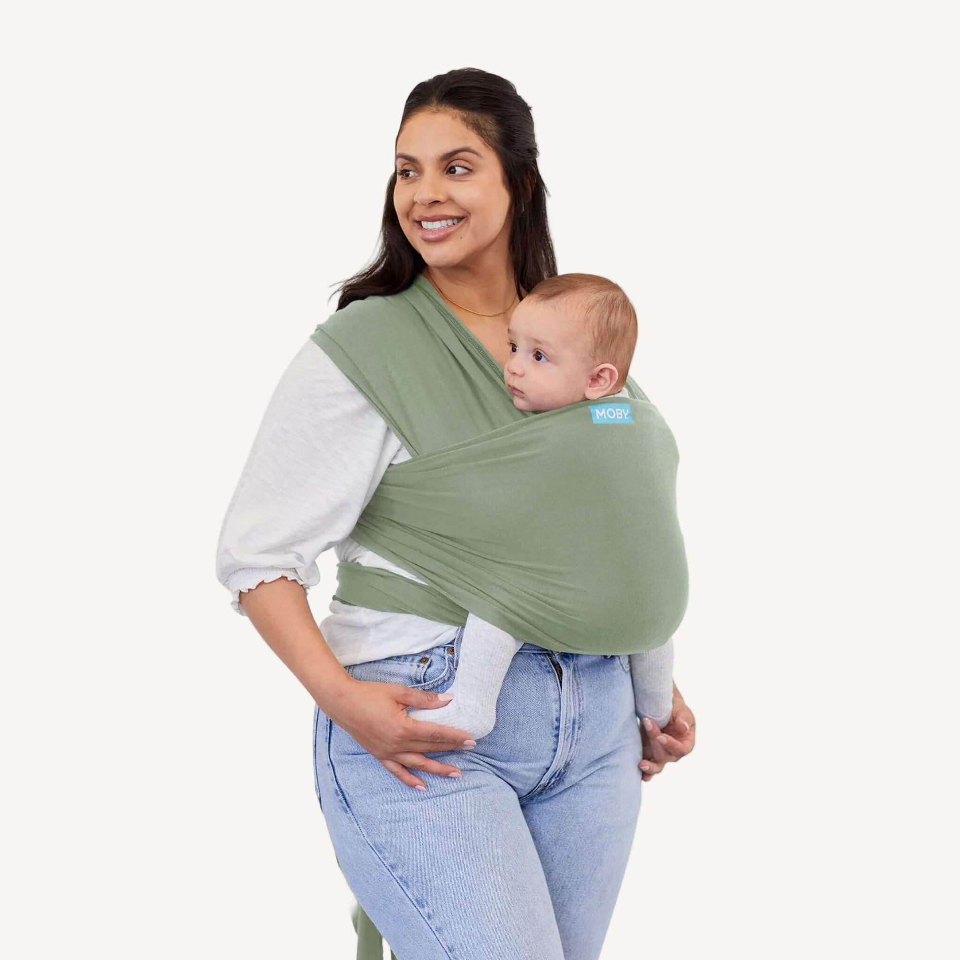 Mother in a white blouse carrying her baby in a Pear green baby wrap with a supportive cross-front hold.