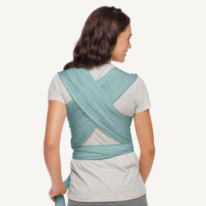 Back view of an adult wearing a teal wrap with fabric crossed over the shoulders and tied securely around the waist.