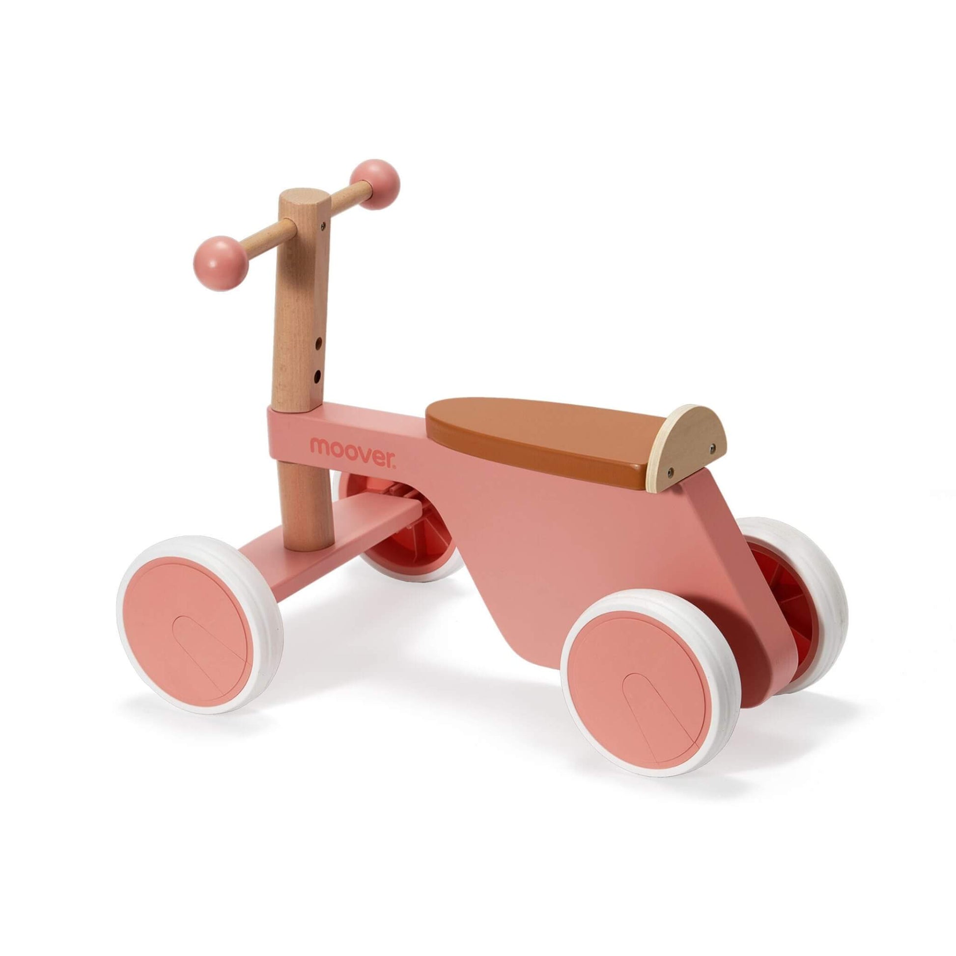 Wooden ride-on bike in pale pink showing four sturdy white wheels, smooth handlebar, and curved seat for toddlers.