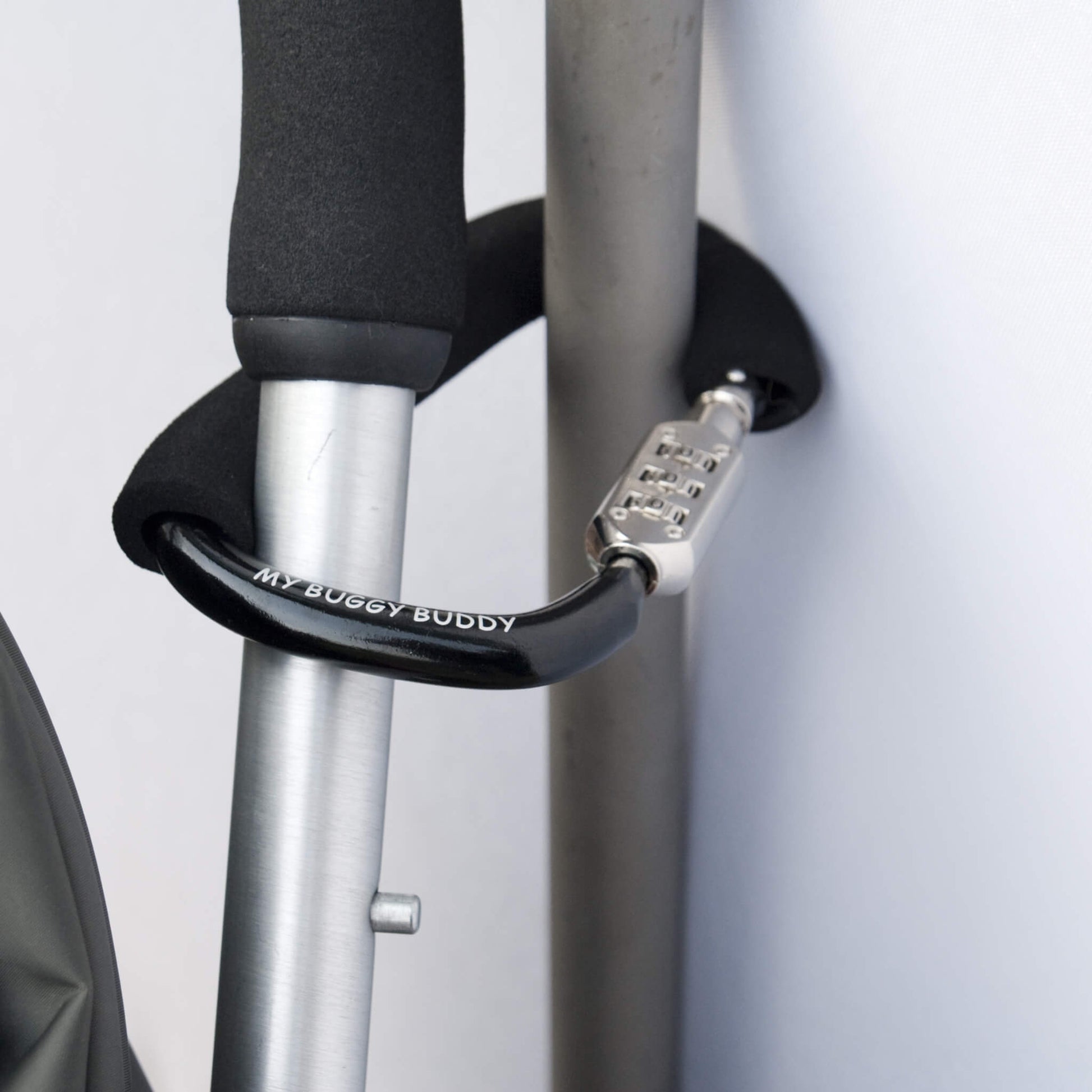 Black foam-handled buggy lock securing a stroller to a metal post, demonstrating anti-theft use.