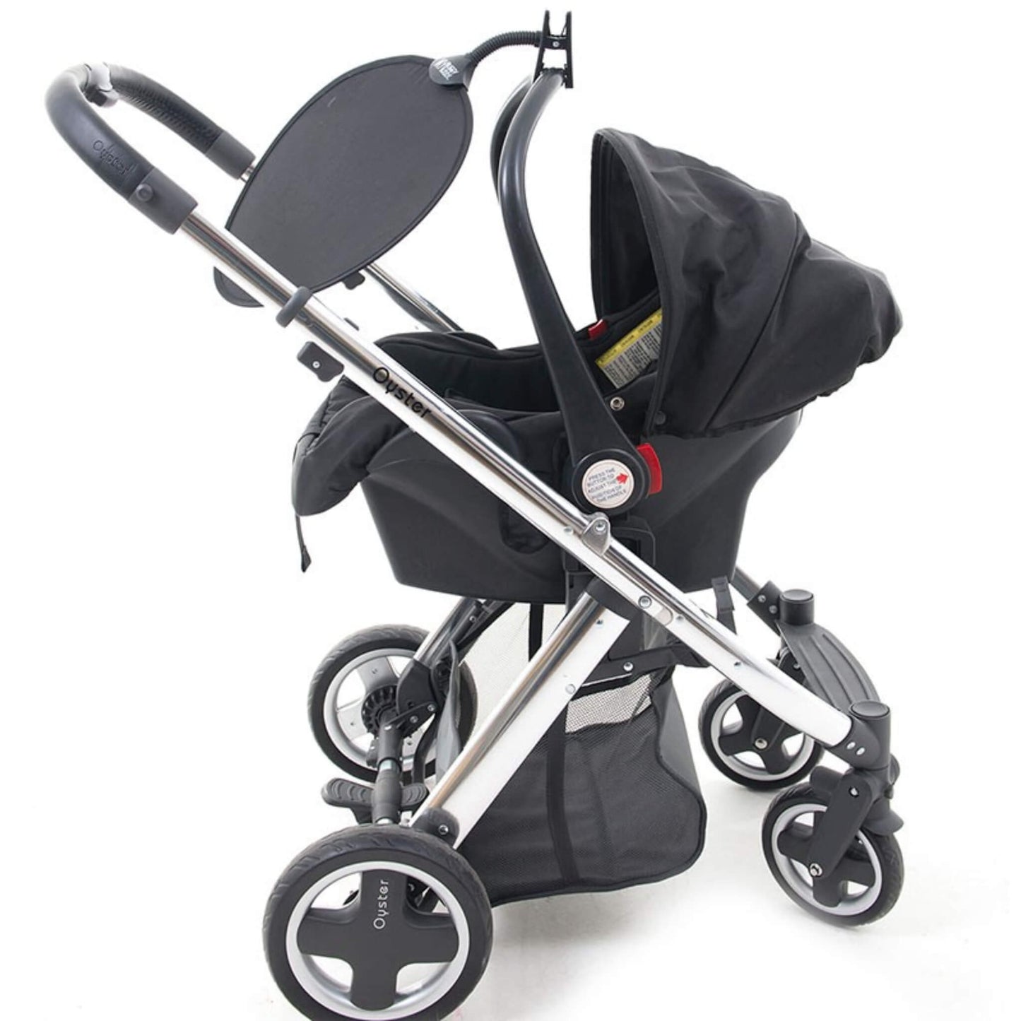 Clip-on sunshade attached to a pushchair handle, positioned to shade a baby car seat from sunlight.