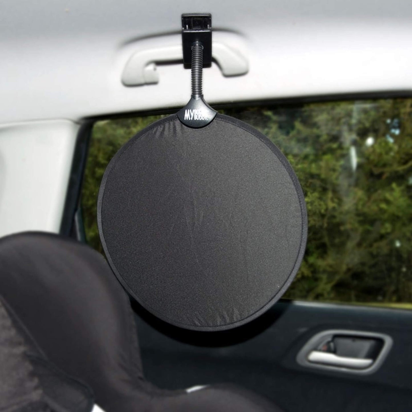 Round car sunshade clipped to an interior handle of a car to protect a baby seat from direct light.
