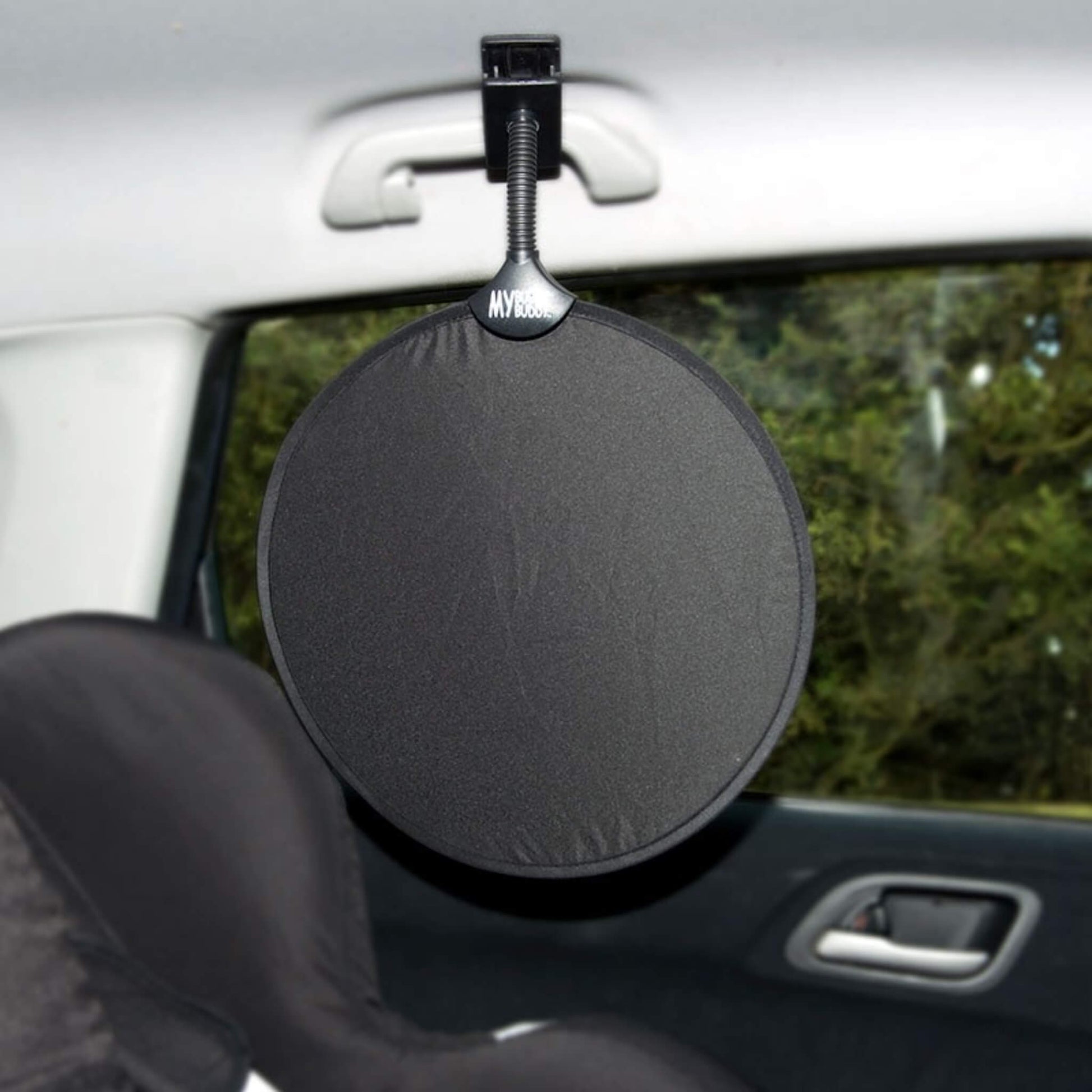 Round car sunshade clipped to an interior handle of a car to protect a baby seat from direct light.