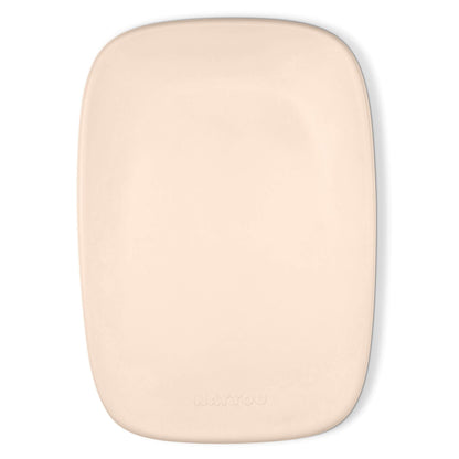 Beige contoured changing pad photographed from above with a smooth surface and rounded corners.