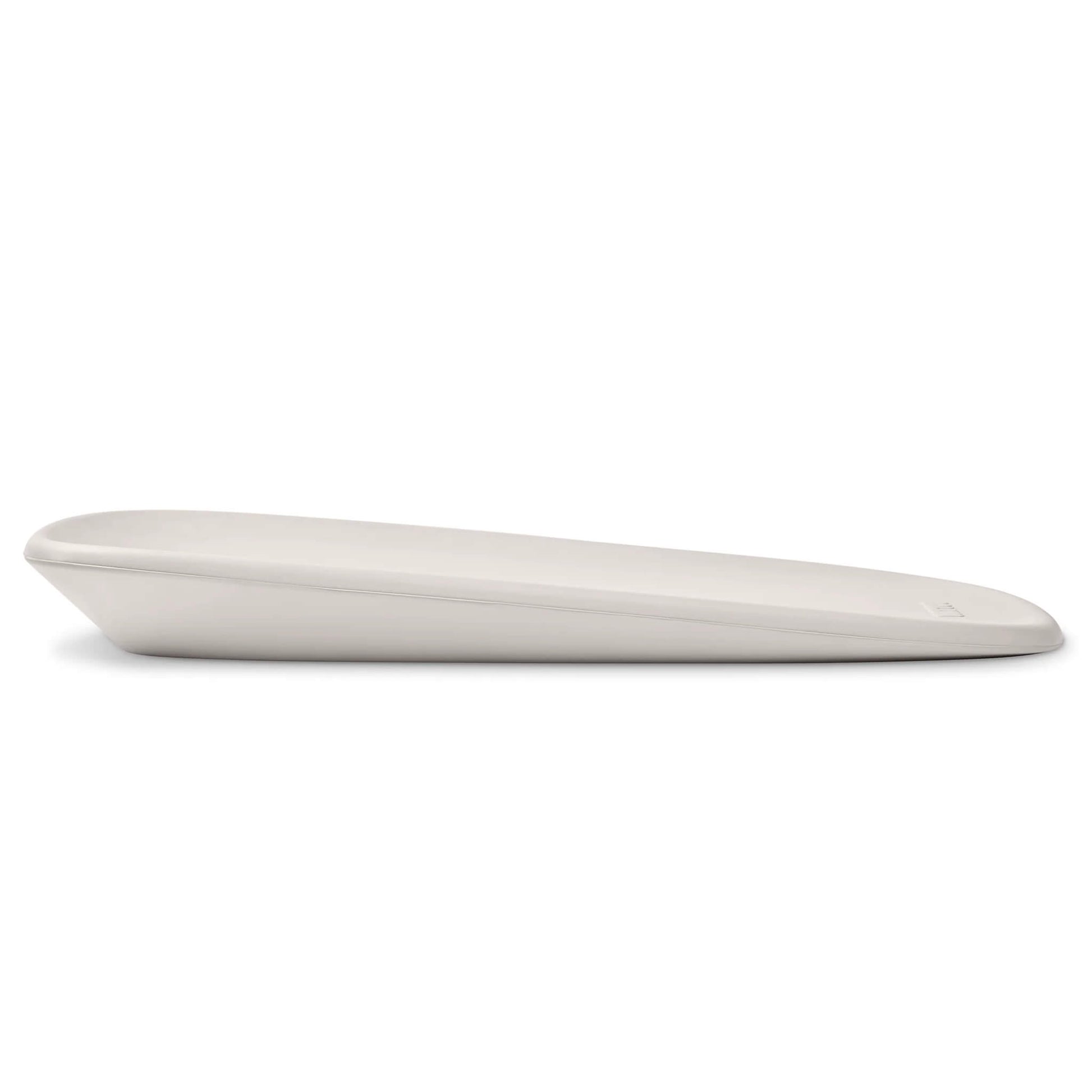 A low side angle of a clay-coloured changing pad highlighting its shallow incline and streamlined shape.