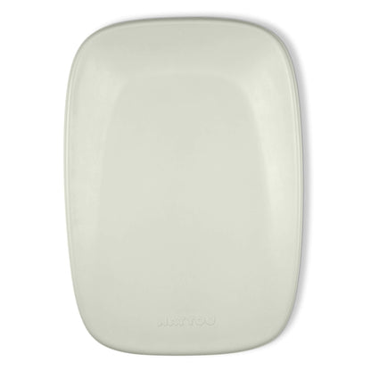 Soft green contoured changing pad photographed from above with a smooth surface and rounded corners.