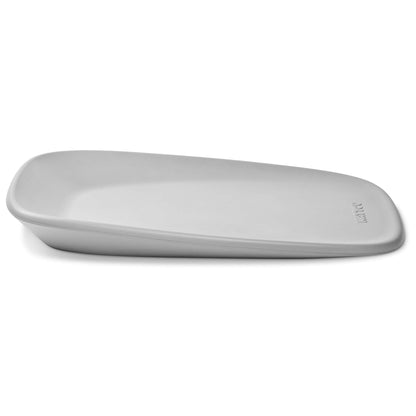 Angled side view of a grey changing pad showing its curved shape and raised sides.