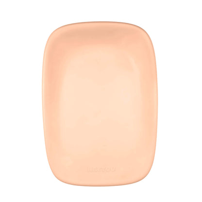 A top-down view of a peach coloured nappy changing pad with curved corners and a smooth recessed centre.