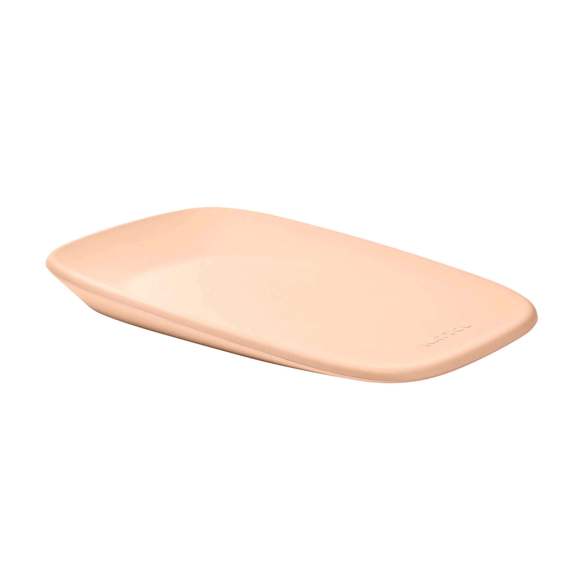 A peach changing pad photographed at a slight angle, highlighting the soft contour and embossed brand name.