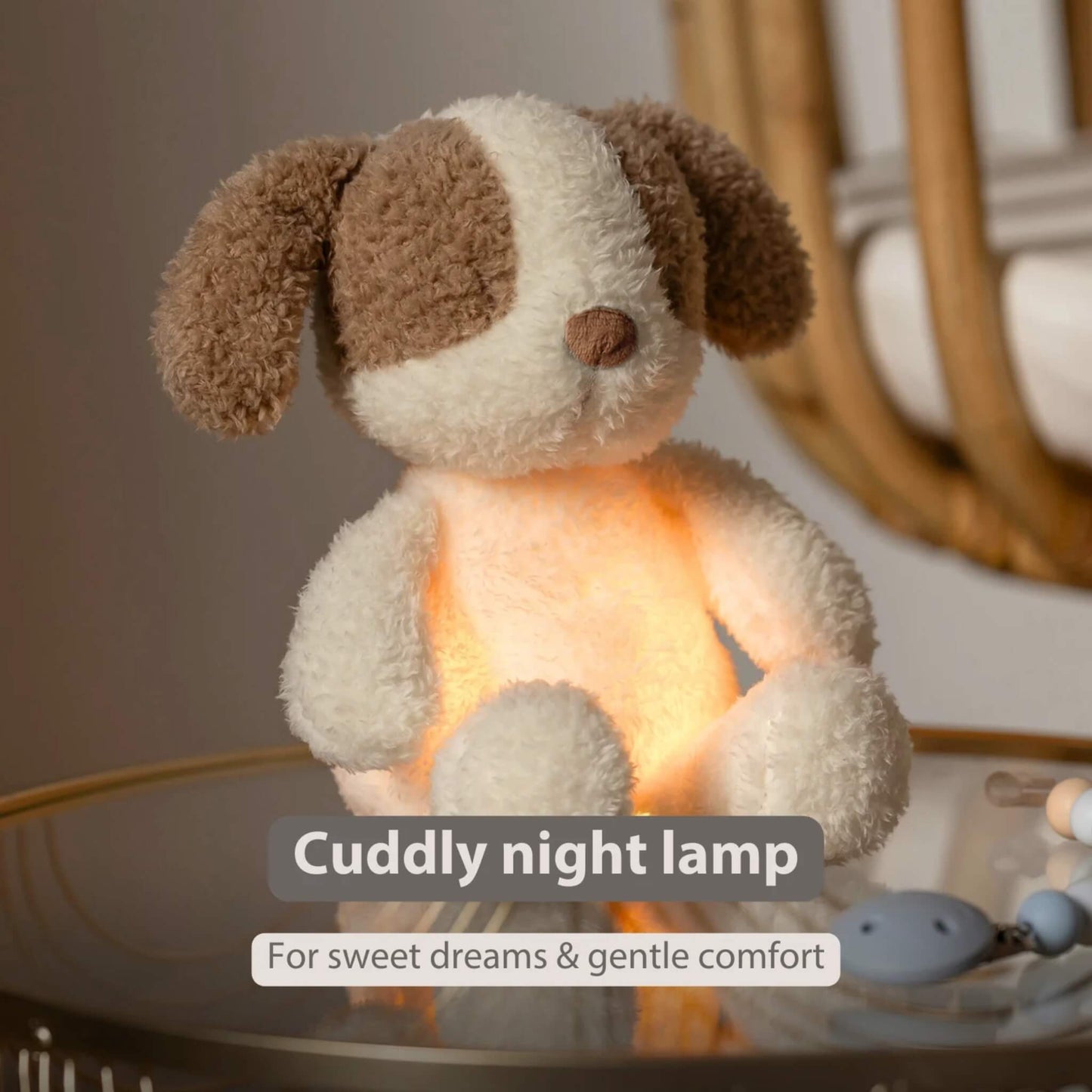 A small plush dog nightlight sitting on a bedside table with a warm amber glow shining through its body.