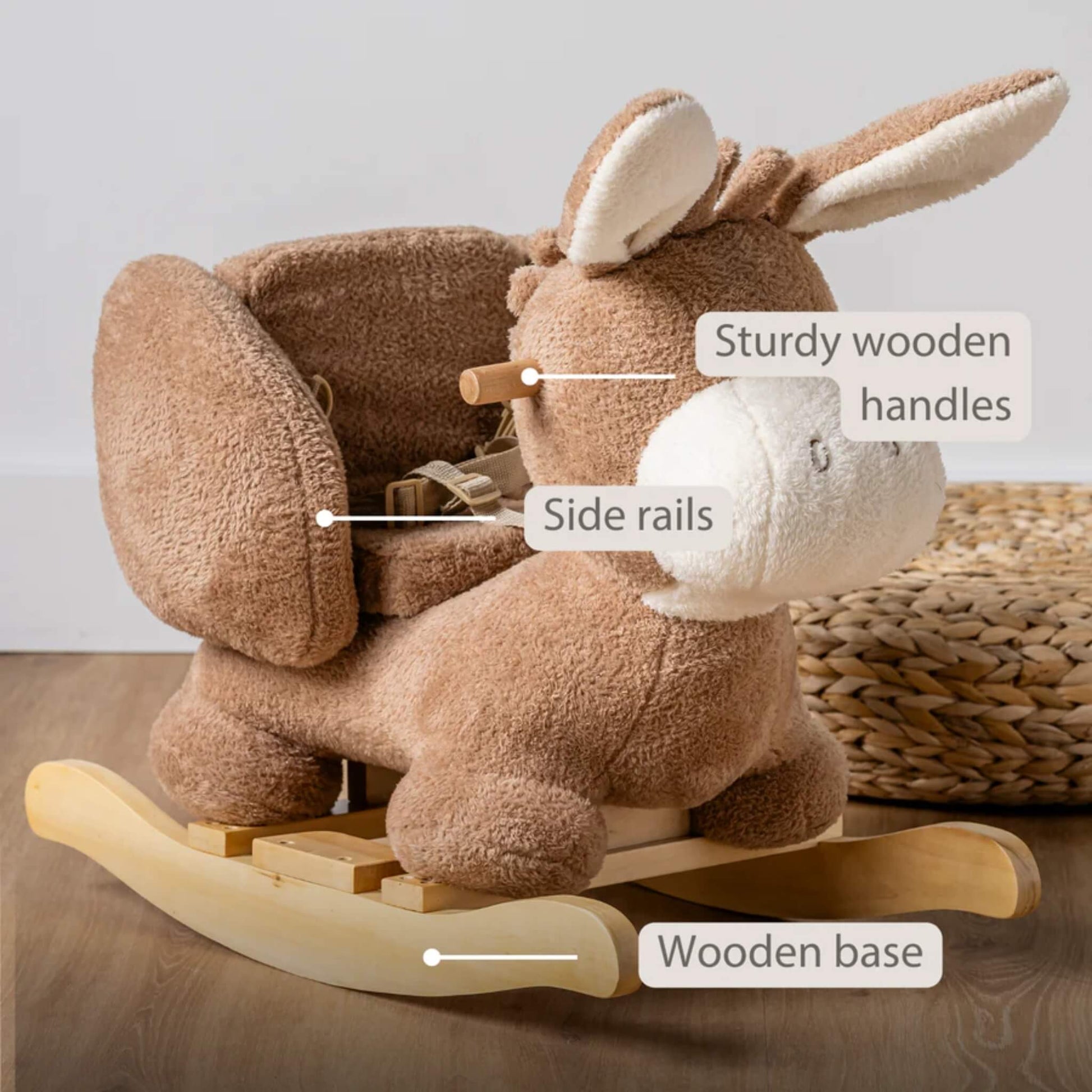 Side view of a beige plush rocking donkey showing wooden handles, padded side rails and a sturdy curved wooden base.