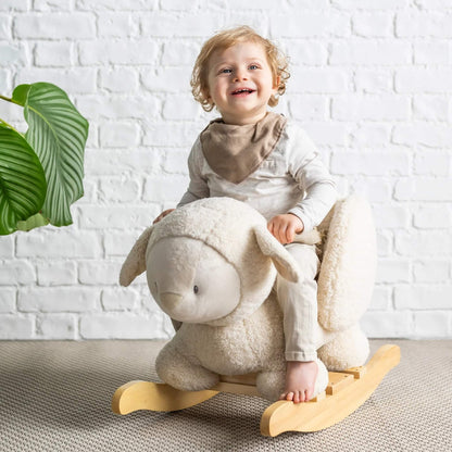 Smiling toddler riding plush rocker in sheep design. Safe, supportive, and ideal for building balance and motor skills.