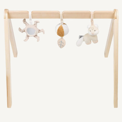 Wooden baby play arch with three soft hanging sensory toys including a mirror sun, textured ball and plush animal, shown against a plain background.