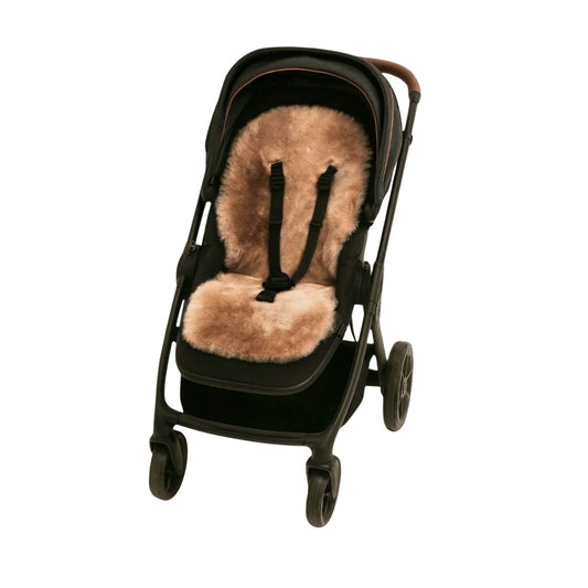 Pram fitted with a Naturally Sheepskins Snuggly rose gold sheepskin liner, showing its plush texture and snug fit with harness slots.