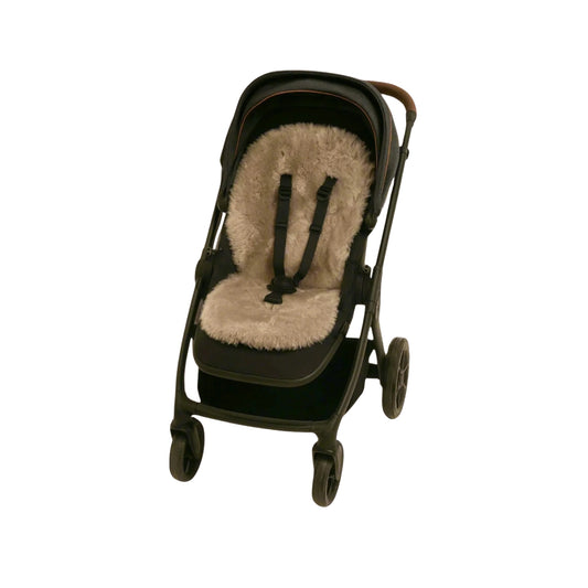 Naturally Sheepskins Snuggly Pram Liner in Taupe fitted into a black pram, with soft Merino sheepskin cushioning visible through the harness slots.