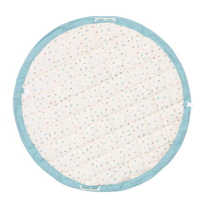 A padded circular play mat shown from the reverse side with a subtle all-over pastel pattern and stitched sections for comfort.