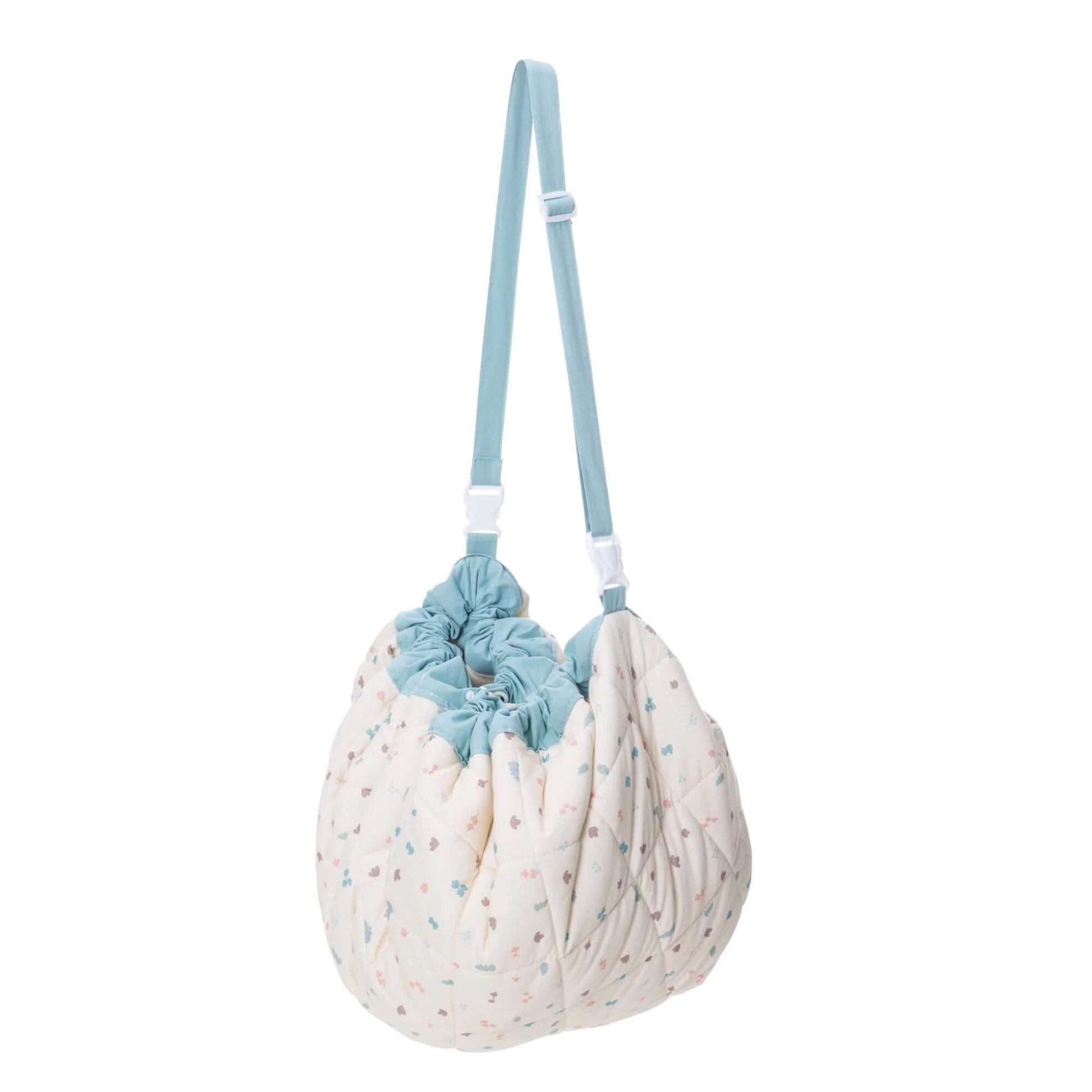 A soft drawstring toy storage bag gathered into a rounded shape with an adjustable shoulder strap for carrying.