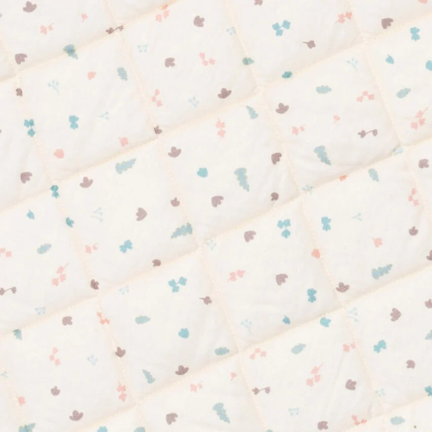 A close-up view of the padded quilted fabric showing diamond stitching and a small repeating pastel print.